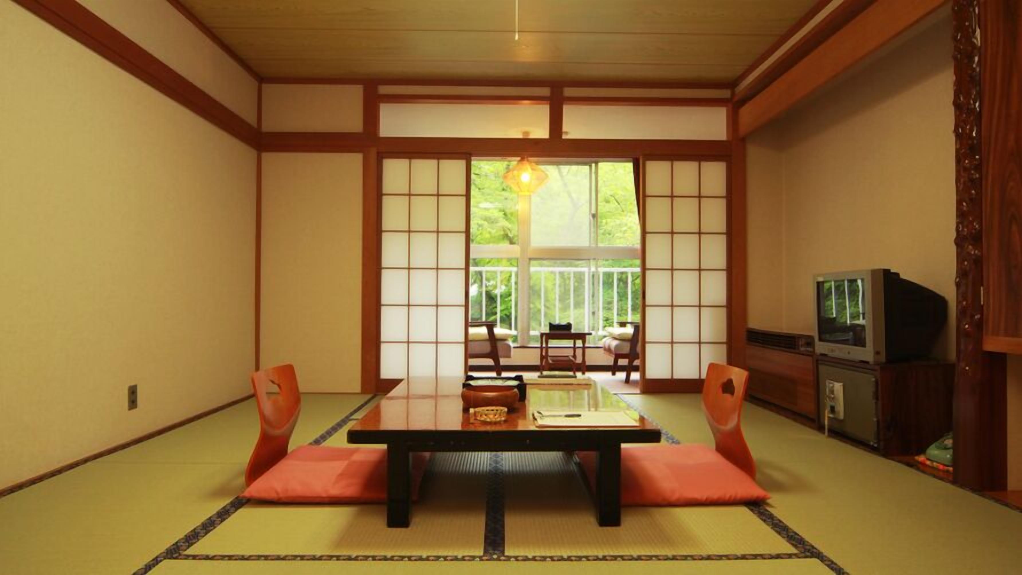 A traditional Japanese-style room with tatami flooring, a low table, and sliding shoji doors.