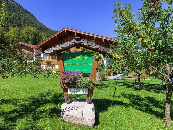 A sign for a mountain lodge with a wooden structure and a stone base.