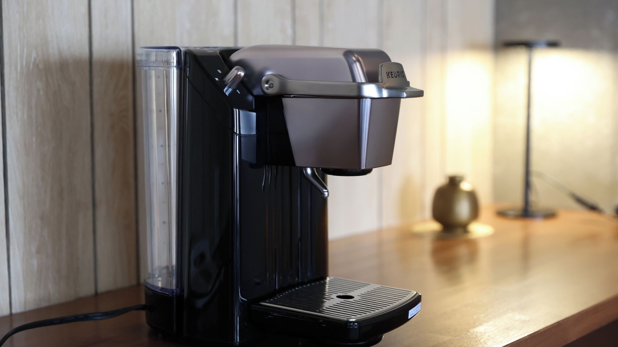A coffee machine on a wooden countertop with a wall in the background.
