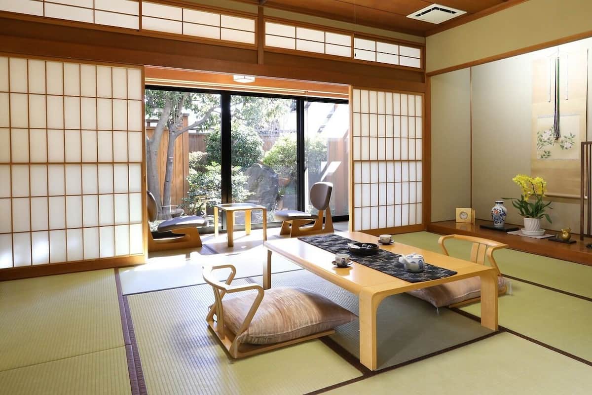 A traditional Japanese room with tatami flooring, a low table, and sliding doors.
