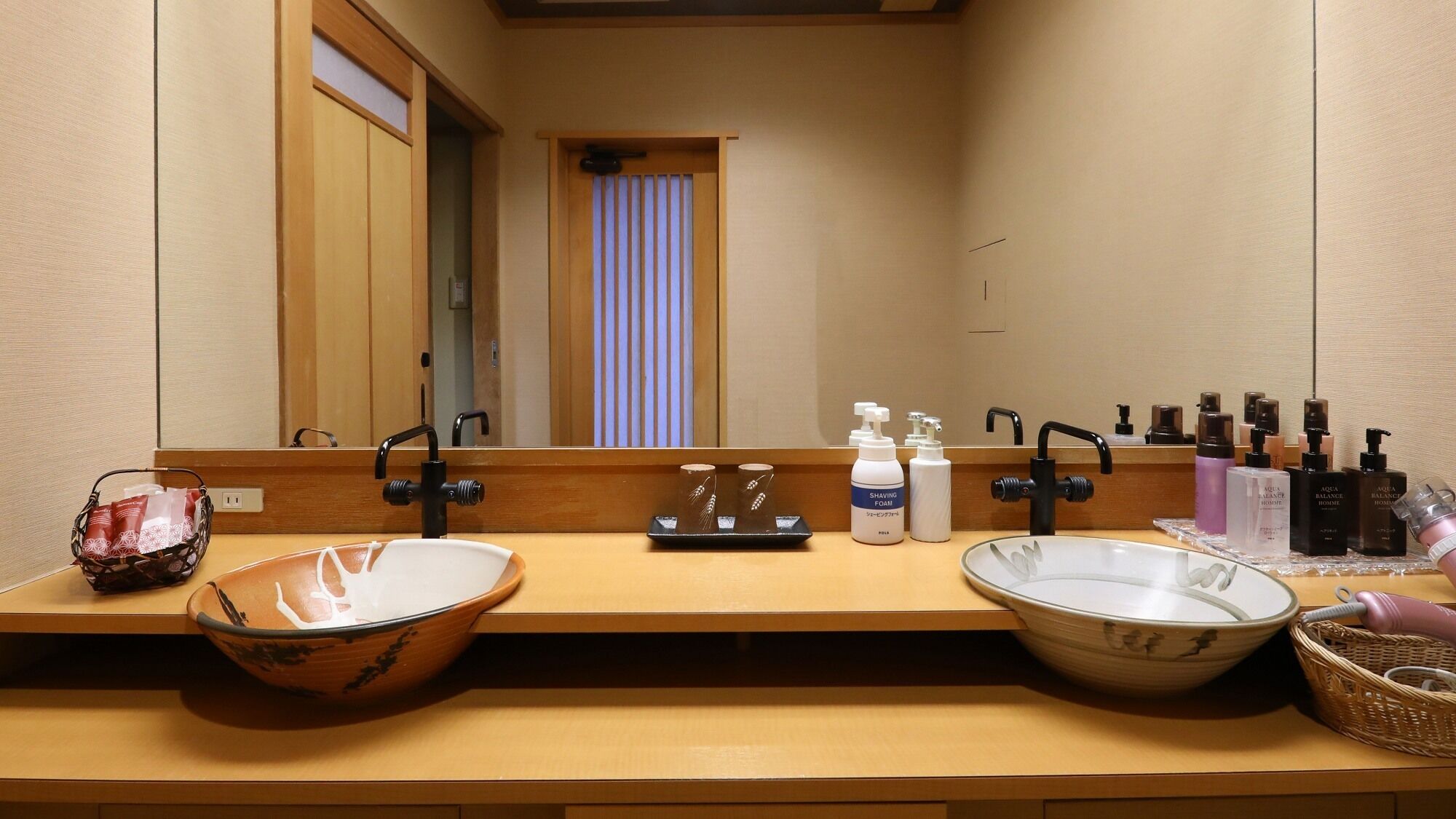 A bathroom with two sinks, a mirror, and toiletries.