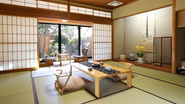 A traditional Japanese room with tatami flooring, a low table, and sliding doors. - Isawa Onsen Hotel Fuji (Fuefuki)