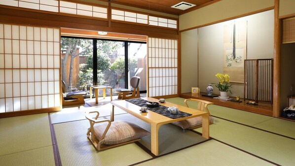 Une pièce de style japonais traditionnel, avec un sol recouvert de tatamis, une table basse et des portes coulissantes.