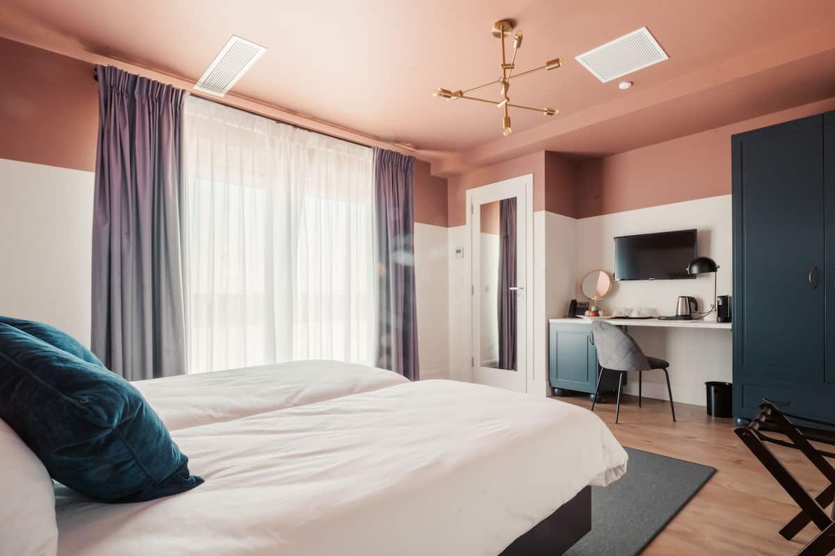 Une chambre moderne avec un grand lit, un bureau et une armoire.