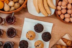 Una mesa con diferentes alimentos, como frutas, huevos y pasteles.