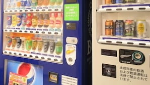 Een automaat met diverse dranken en snacks, en een aparte automaat met blikjes bier.