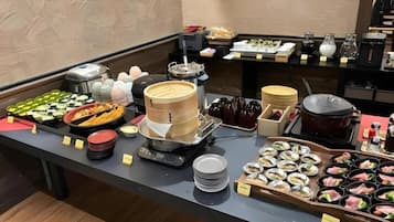 Un bufé con diferentes opciones de comida y una estación de café.