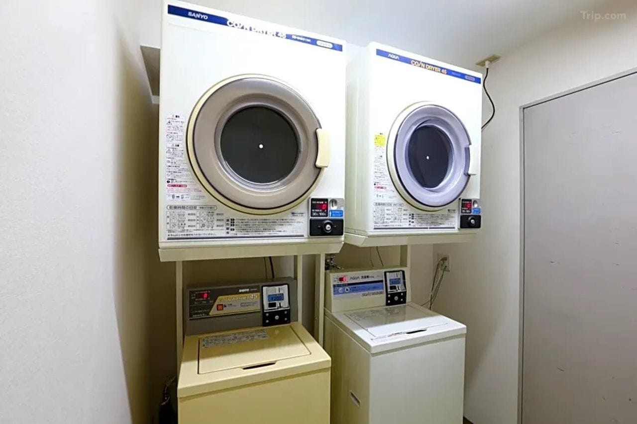 A laundry area with two front-loading washing machines and a dryer.