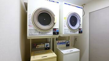 A laundry area with two front-loading washing machines and a dryer.