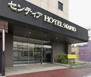Fachada moderna de un hotel con un cartel que indica su nombre.