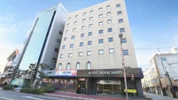 Un hotel con fachada moderna, varios pisos y una entrada destacada.