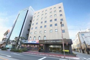 Un hotel con fachada moderna, varios pisos y una entrada destacada.