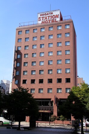Un hotel de varios pisos con un letrero que dice 'Nihgata Station Hotel'.