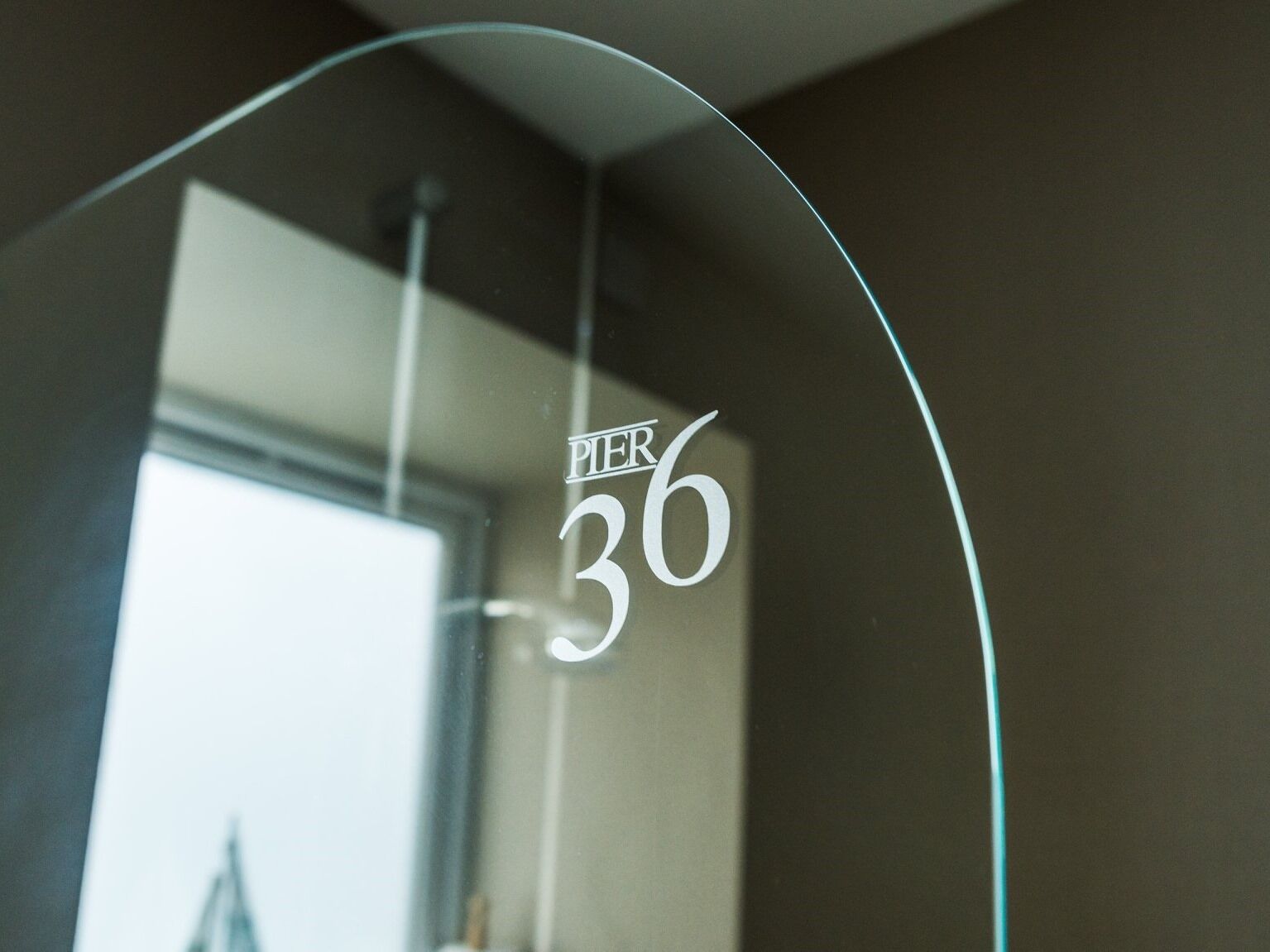A glass door with the inscription "PIER 36" and a curved frame.