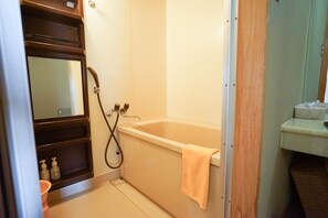 Ein Badezimmer mit einer Badewanne, einer Dusche und einem Waschbecken.