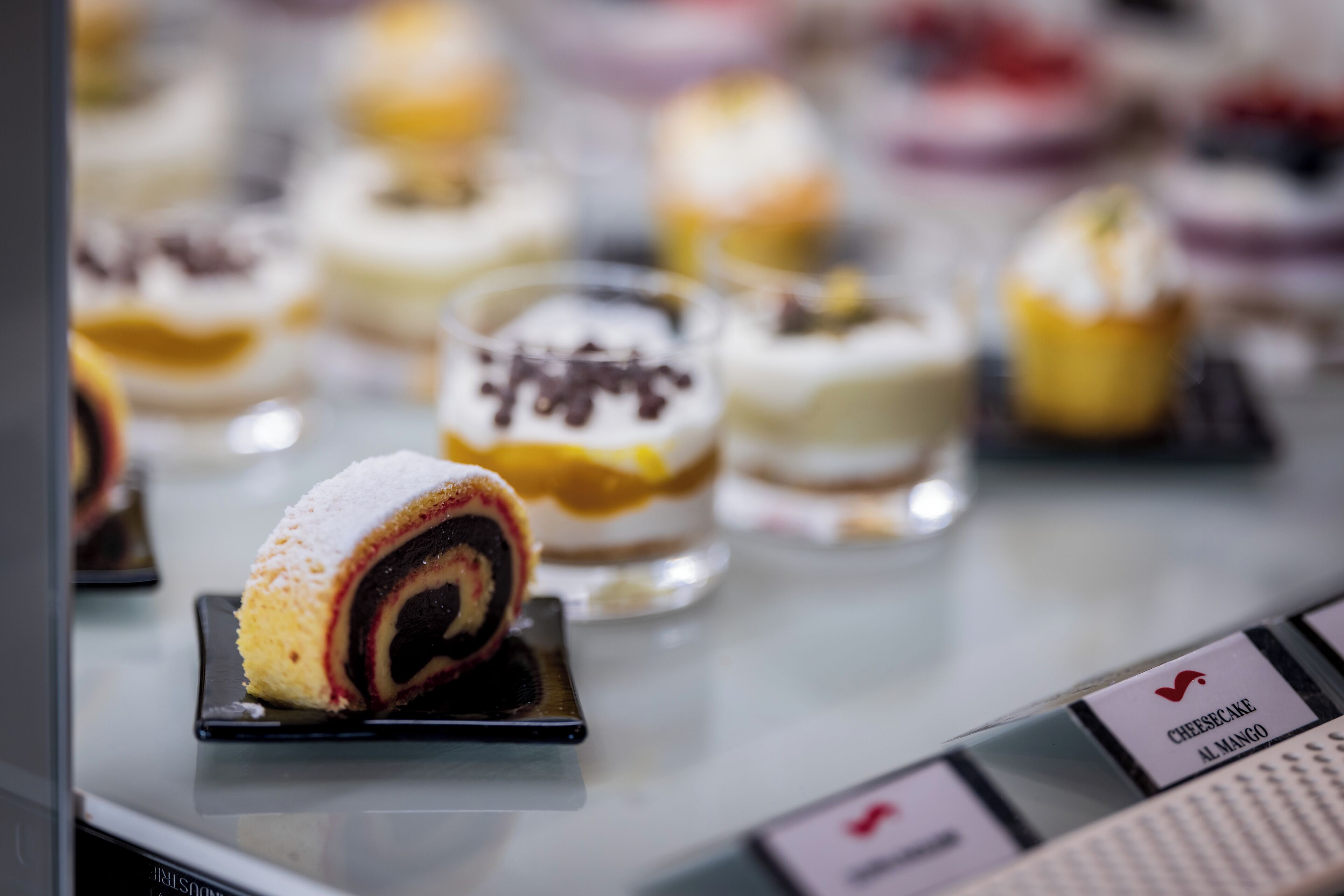 Une variété de desserts étaient présentés, notamment un gâteau roulé et un gâteau au fromage garni de mangue.