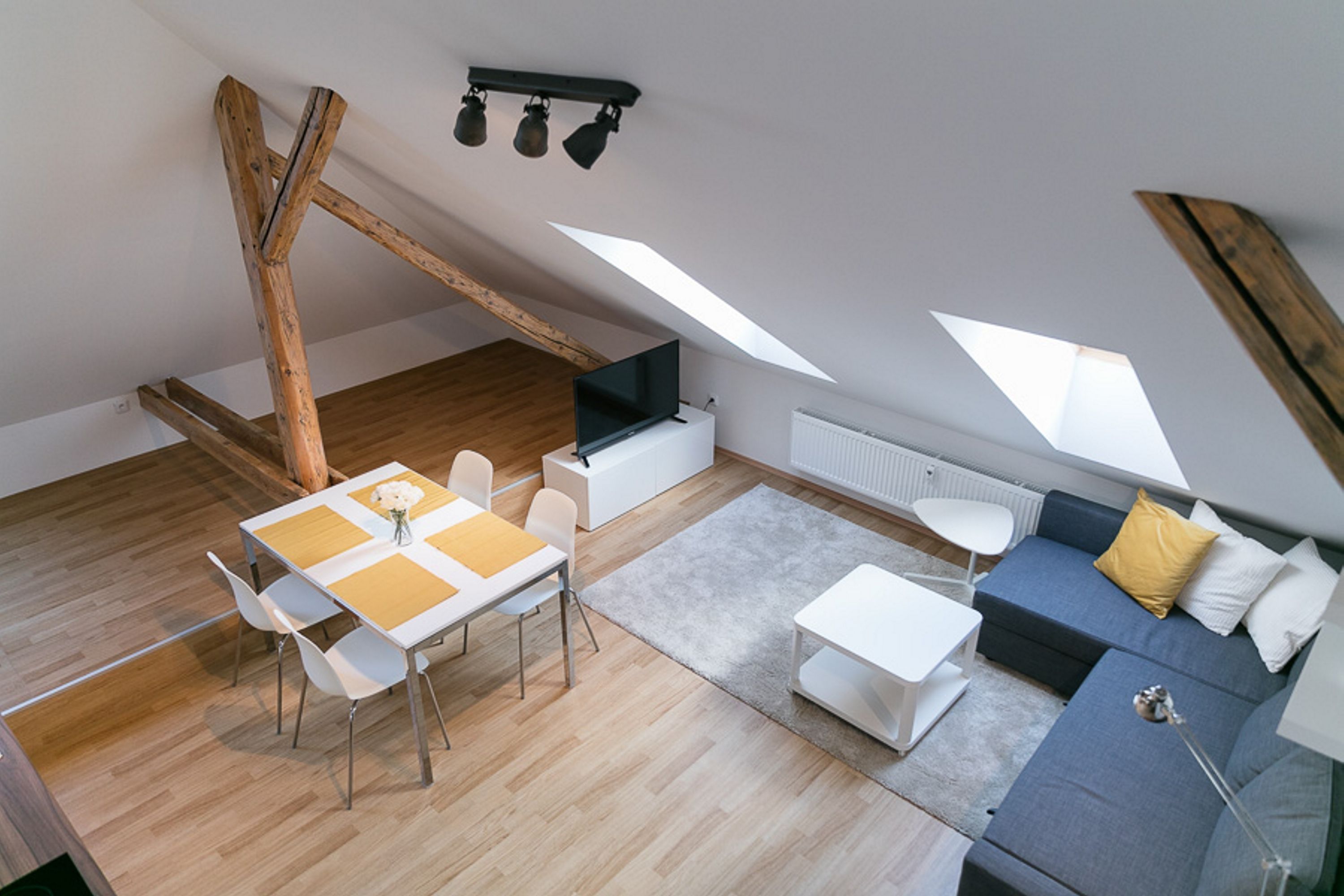 Un loft moderno con comedor, sofá y televisor.