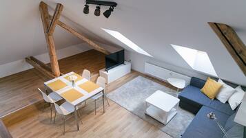 Un loft moderno con comedor, sofá y televisor.
