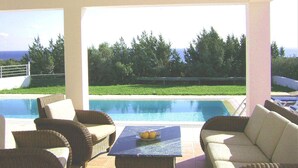 A poolside area with wicker furniture and a table with fruit. - Villa Chevalier at Kiotari Beach,  south of Lindos (Dodekanissos)