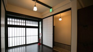 A hotel room with a large sliding door, a fire extinguisher, and a ceiling light fixture. - Nijo Yu-Rakukan (Kyoto)