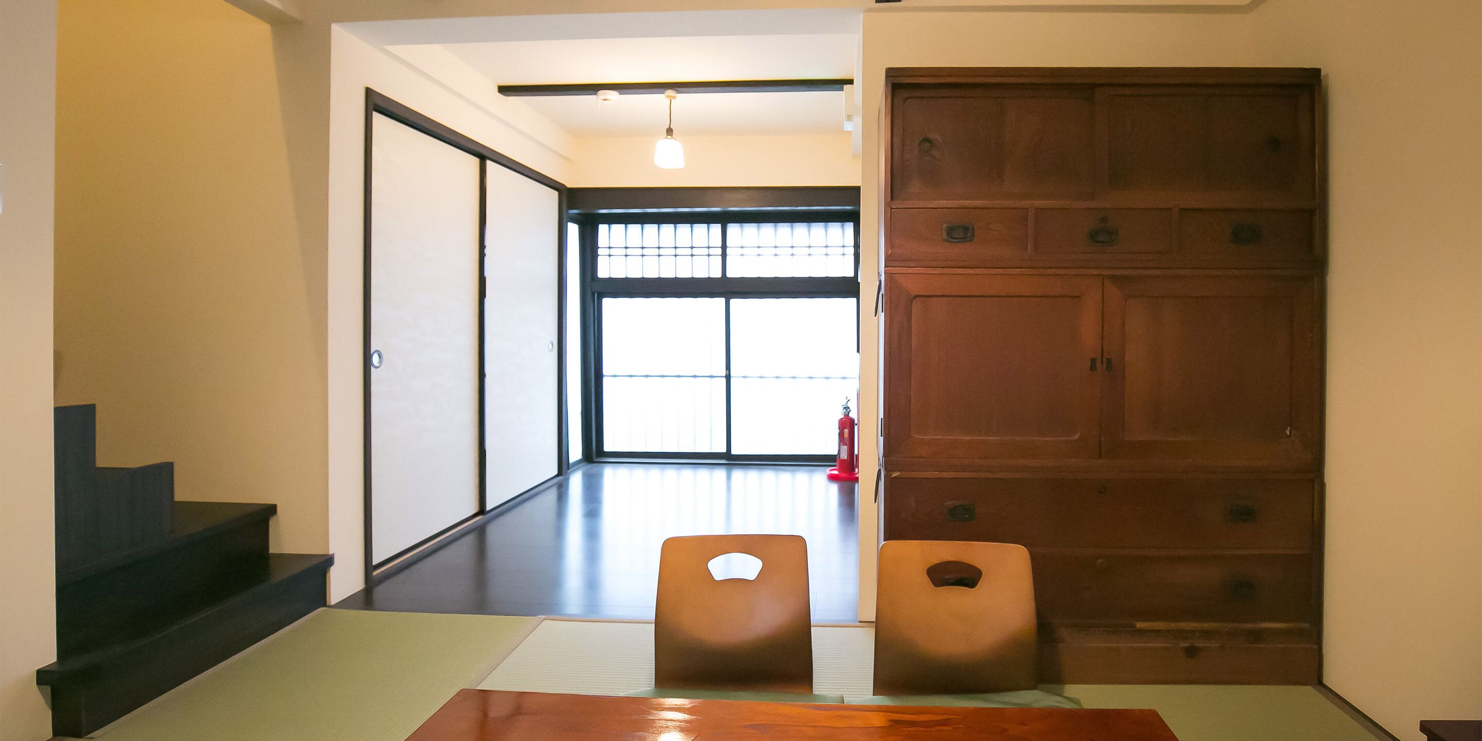 A room with a wooden door, a tatami mat, and a low table.