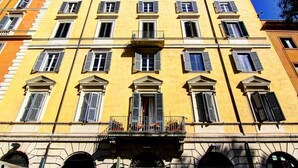 Un bâtiment jaune doté de nombreuses fenêtres et de balcons.