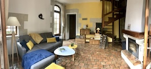 Un salon chaleureux avec un canapé gris, une table basse et une cheminée.