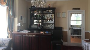 A bar/reception area with a chandelier, a liquor cabinet, and a dining room sign. - White Lodge Guest House (Skegness)
