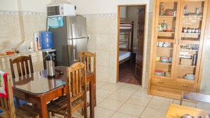 A compact kitchen with a refrigerator, microwave, and wooden cabinets.