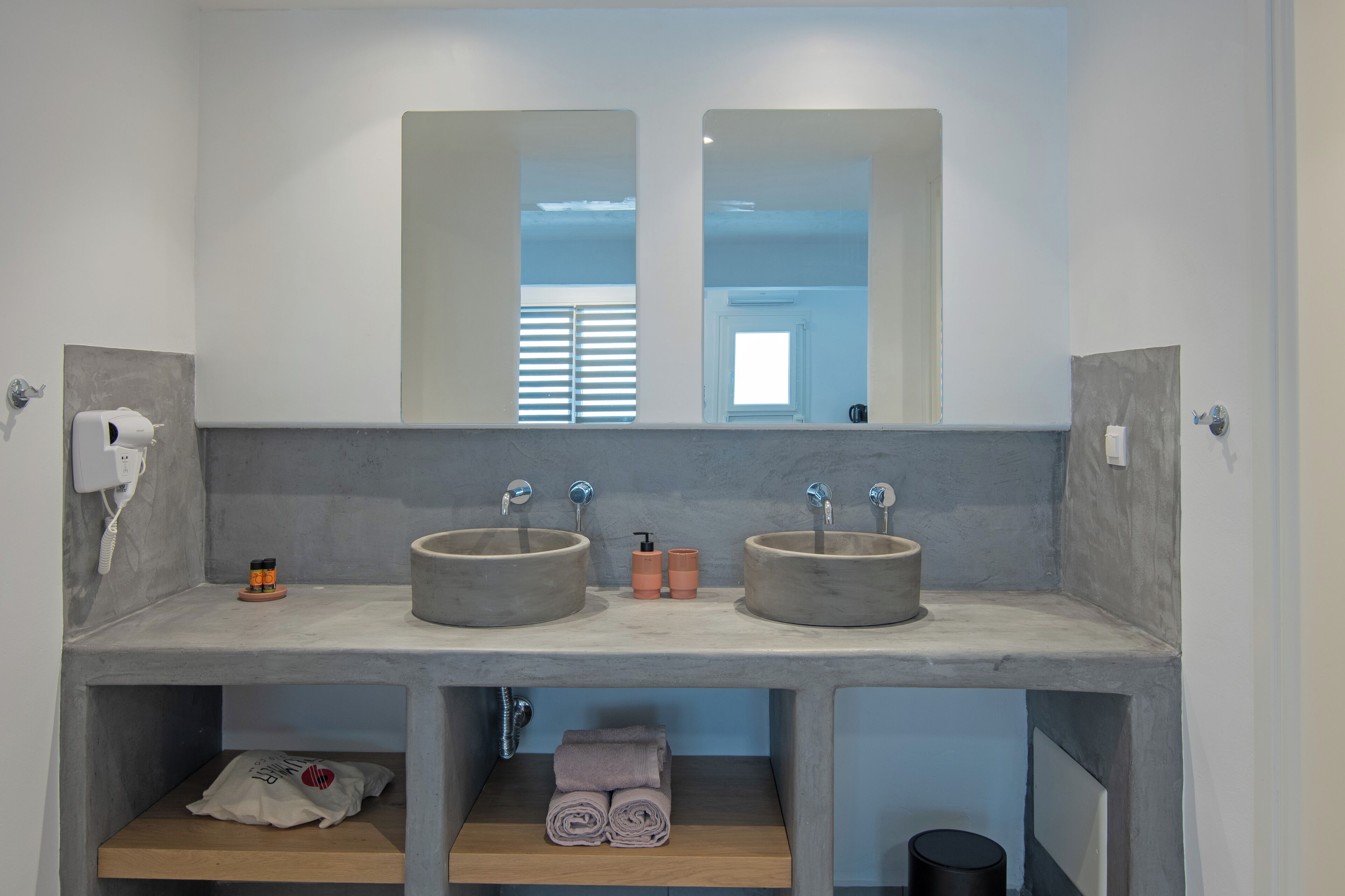 A bathroom with two sinks, a towel rack, and a mirror.