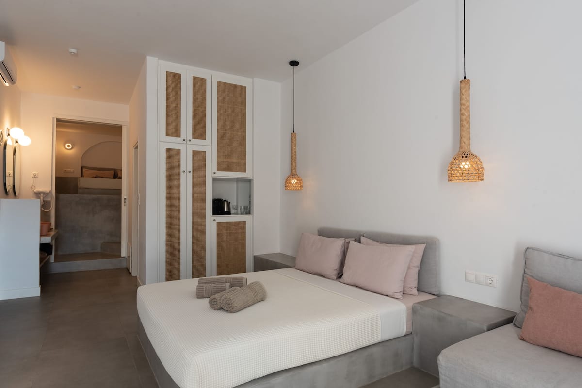 Une chambre à coucher moderne avec un lit, des tables de chevet, une armoire et un luminaire suspendu.
