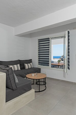 Deluxe Suite 2-4 Adults with Partial Sea and Castle View   (Doto) | Living area | Flat-screen TV - Ihthioessa Boutique Hotel (Astypalaia)