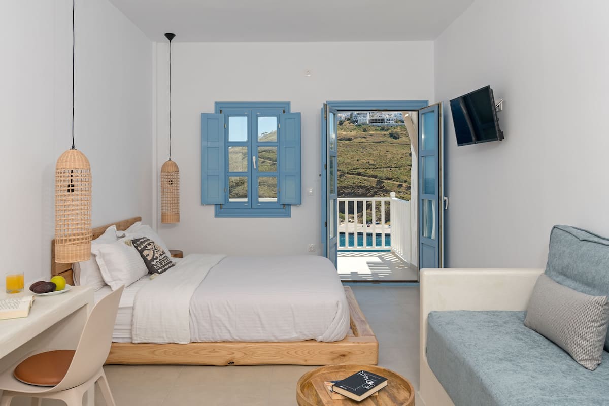 Une chambre à coucher avec un lit, une table de chevet et une vue sur l’extérieur.