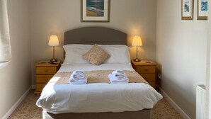 A neatly made bed with two pillows, a bedside lamp, and a framed picture on the wall. - Kilmartin Hotel (Lochgilphead)