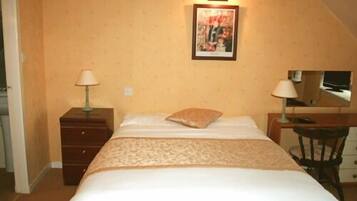 A bedroom with a bed, a nightstand, a dresser, a desk, and a chair. There is a framed picture on the wall above the bed.