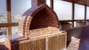 Un horno de ladrillo al aire libre con vistas a un paisaje urbano a través de amplios ventanales.