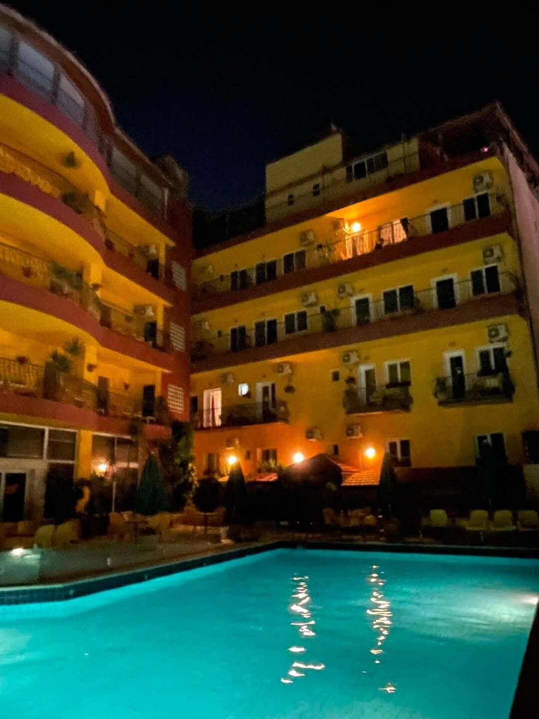 Un hotel de varios pisos con balcones y una piscina.