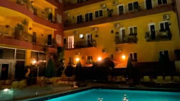 Un hotel de varios pisos con balcones y una piscina.