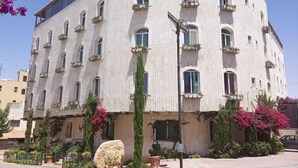 Un edificio de varios pisos con fachada curva, varios balcones y una entrada central.