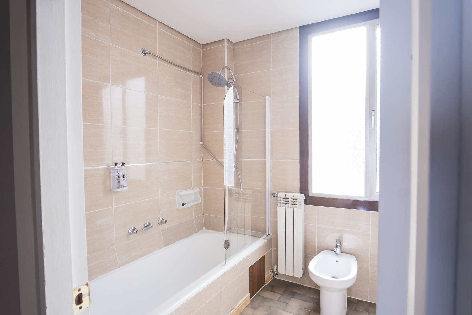 A modern bathroom with a bathtub, shower, and sink.