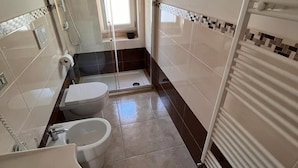 A bathroom with a bathtub, toilet, and shower. - B&B Kalypso (Gallipoli)