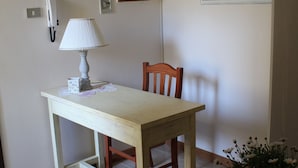 A dining area with a table, chairs, a lamp, a painting, and a flower arrangement. - B&B Kalypso (Gallipoli)