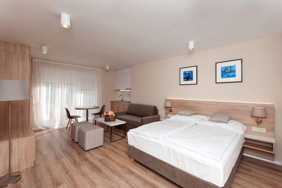 Una habitación de hotel moderna con una cama grande, un escritorio, un sofá y un comedor.