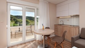 Cozinha moderna com área de jantar, varanda com vista panorâmica e porta de vidro deslizante.
