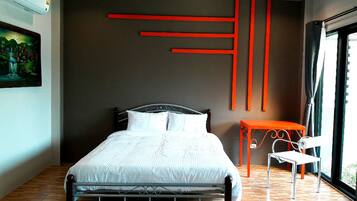 A modern bedroom with a metal bed frame, a white bedspread, and a painting of a landscape on the wall.