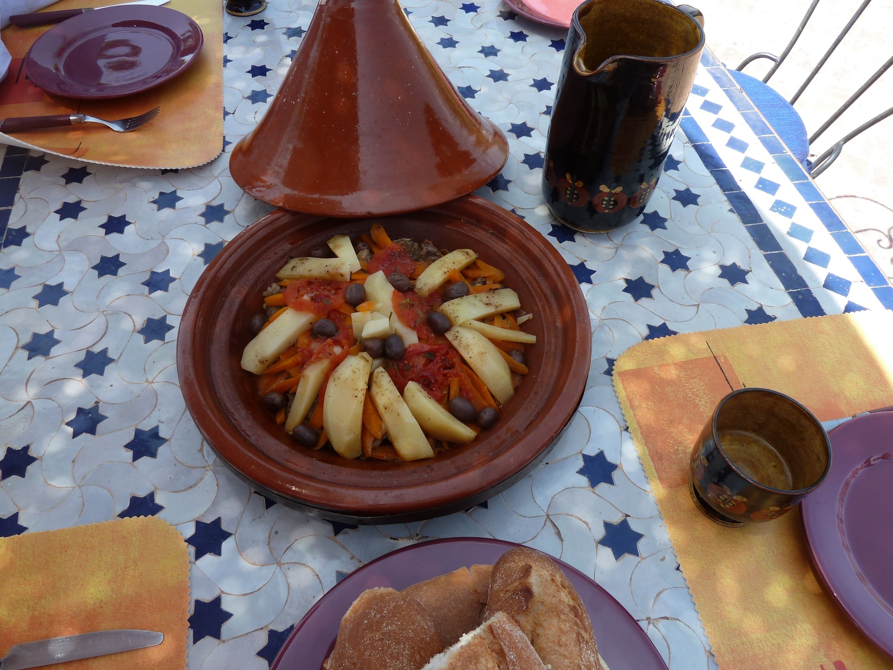 Een traditionele Marokkaanse tajine op een tafelkleed met een stervepatroon.