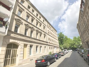 Um edifício de vários andares com arquitetura clássica, com grandes janelas e fachada simétrica.