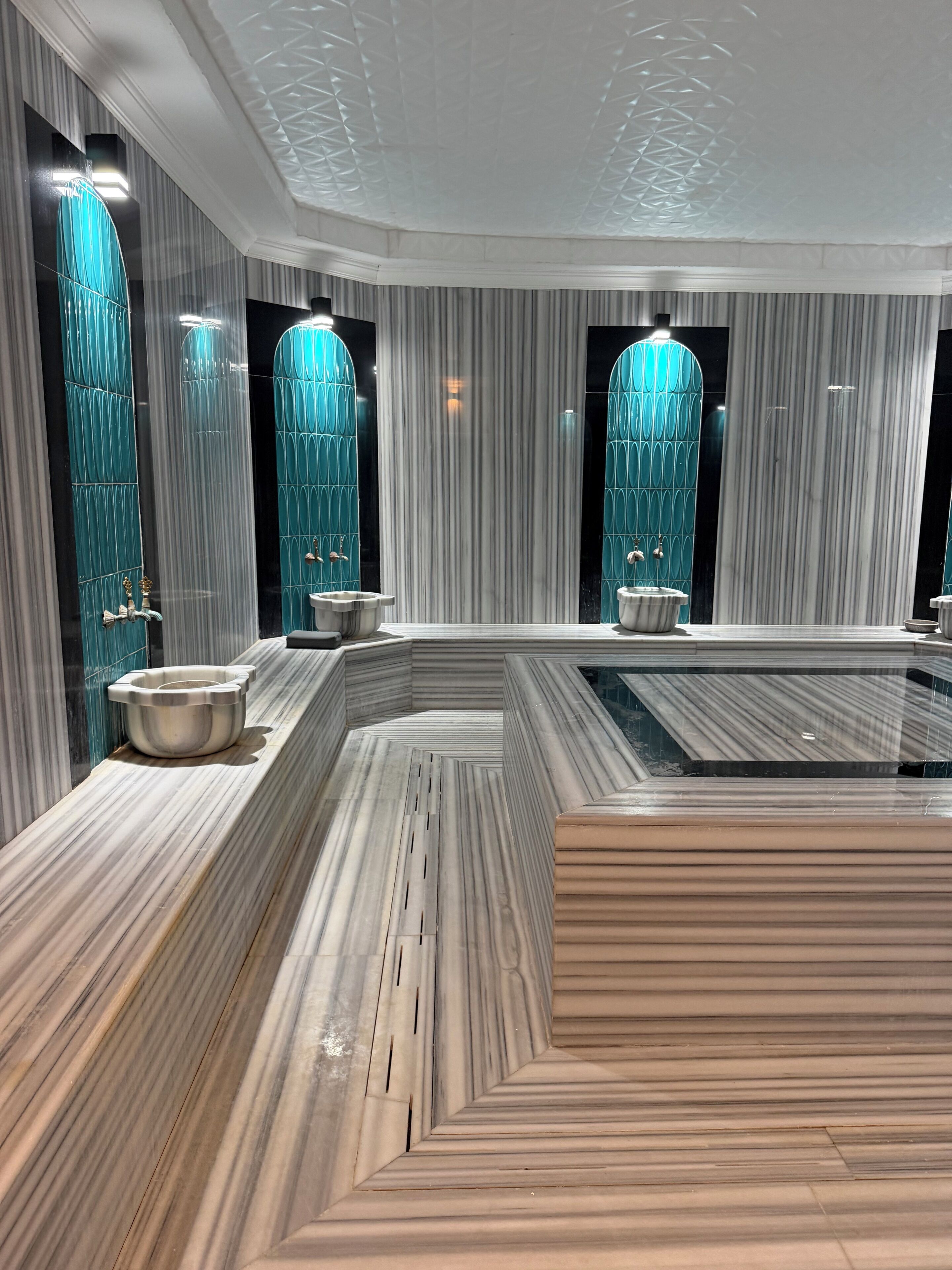 A modern bathroom with a marble vanity, a freestanding bathtub, and a large mirror.