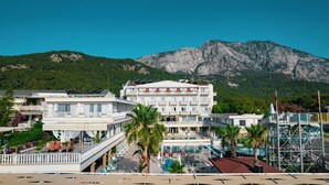 Un hotel con varios pisos, zonas de estar al aire libre y una piscina.