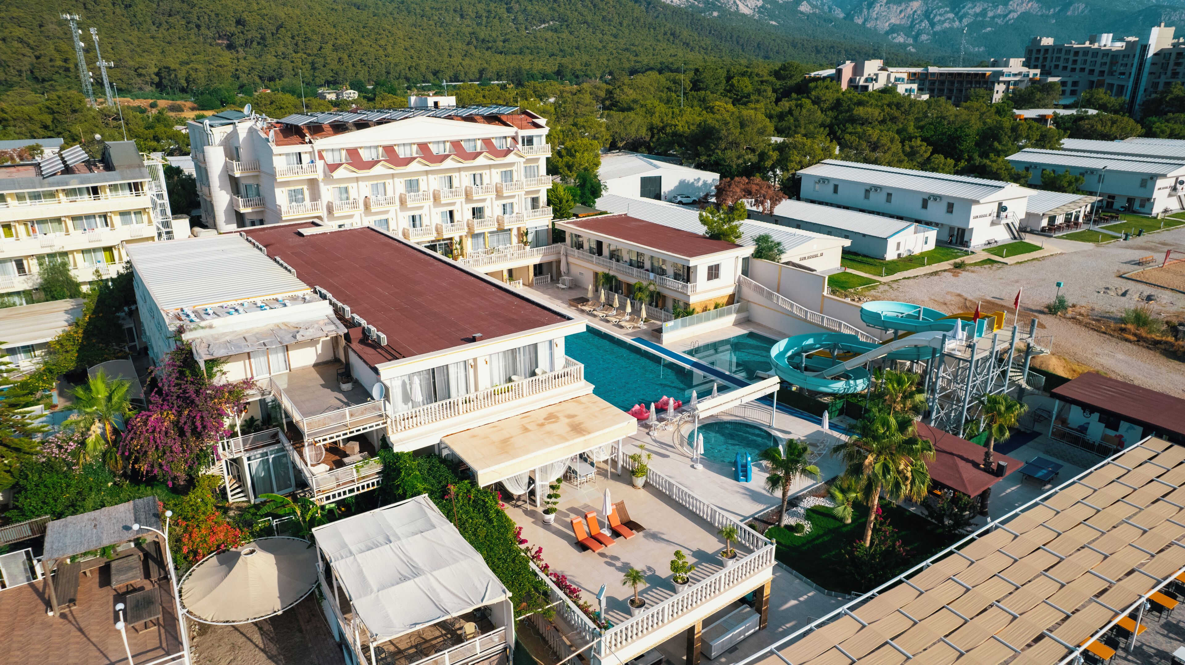 A resort with multiple buildings, a central pool, and a water slide.